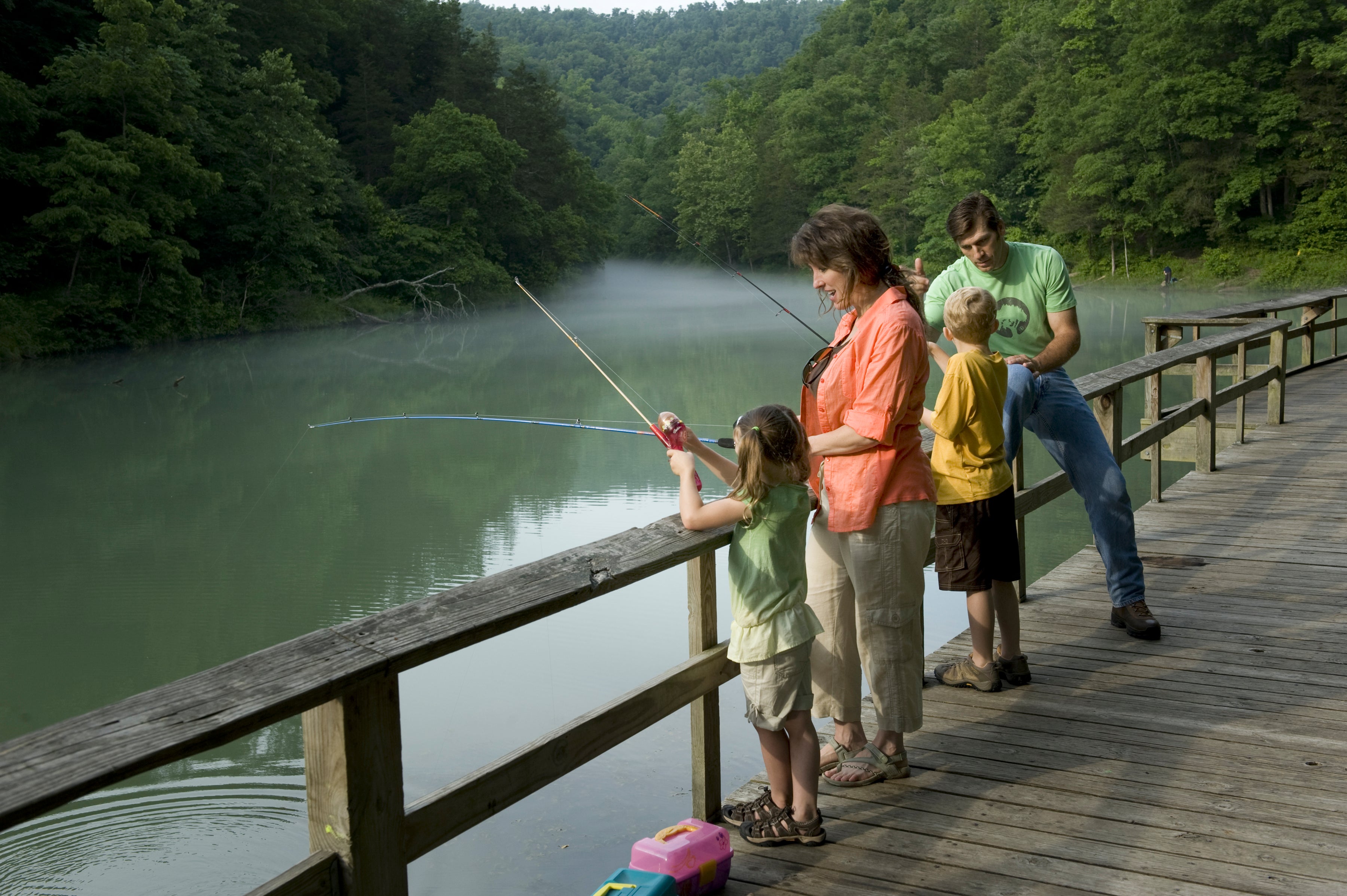 A family fishing from the pier on Mirror Lake in Arkansas