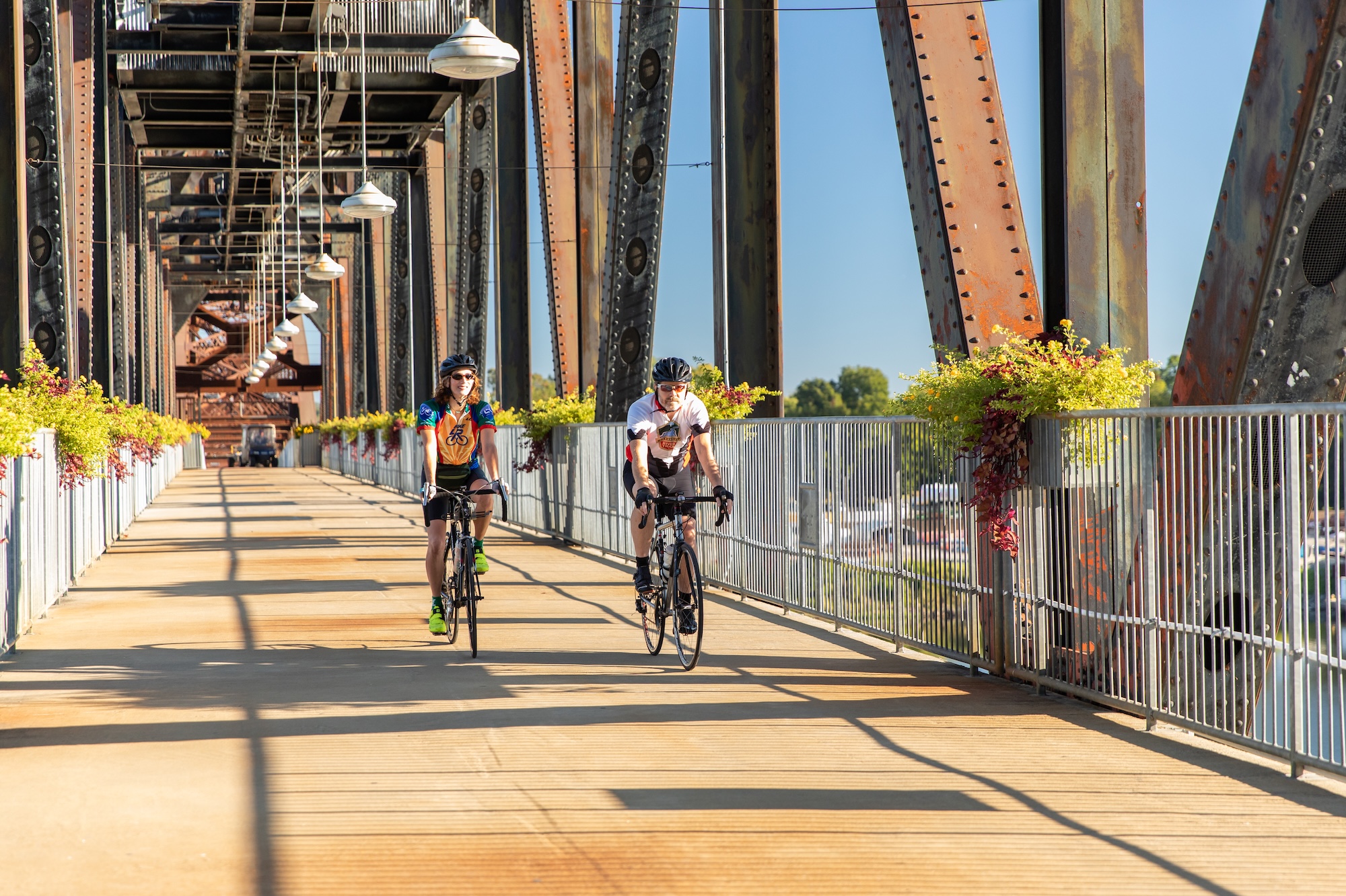 couple road cycling on the clinton library bridge