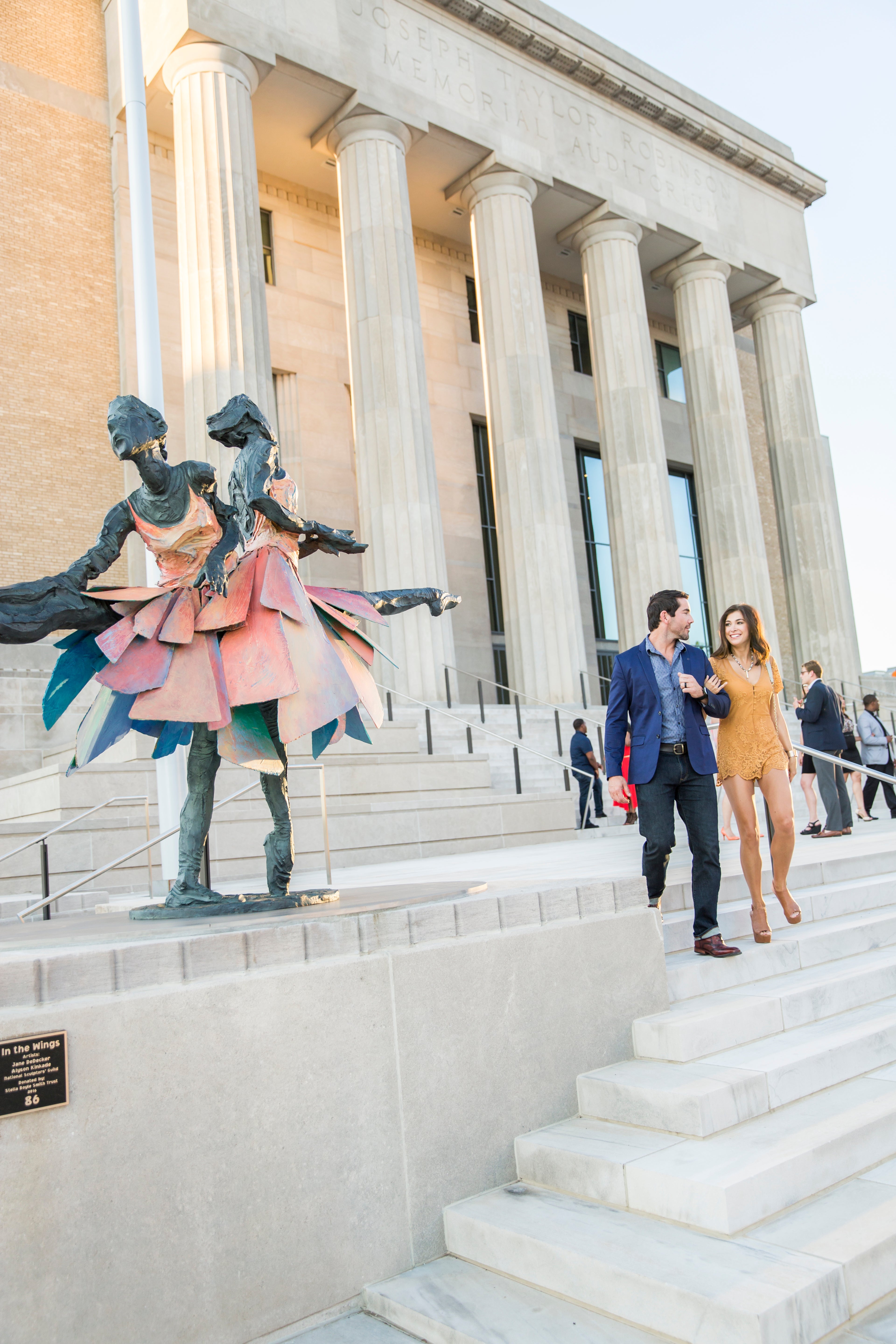 people outside of robinson theater near a ballet sculpture