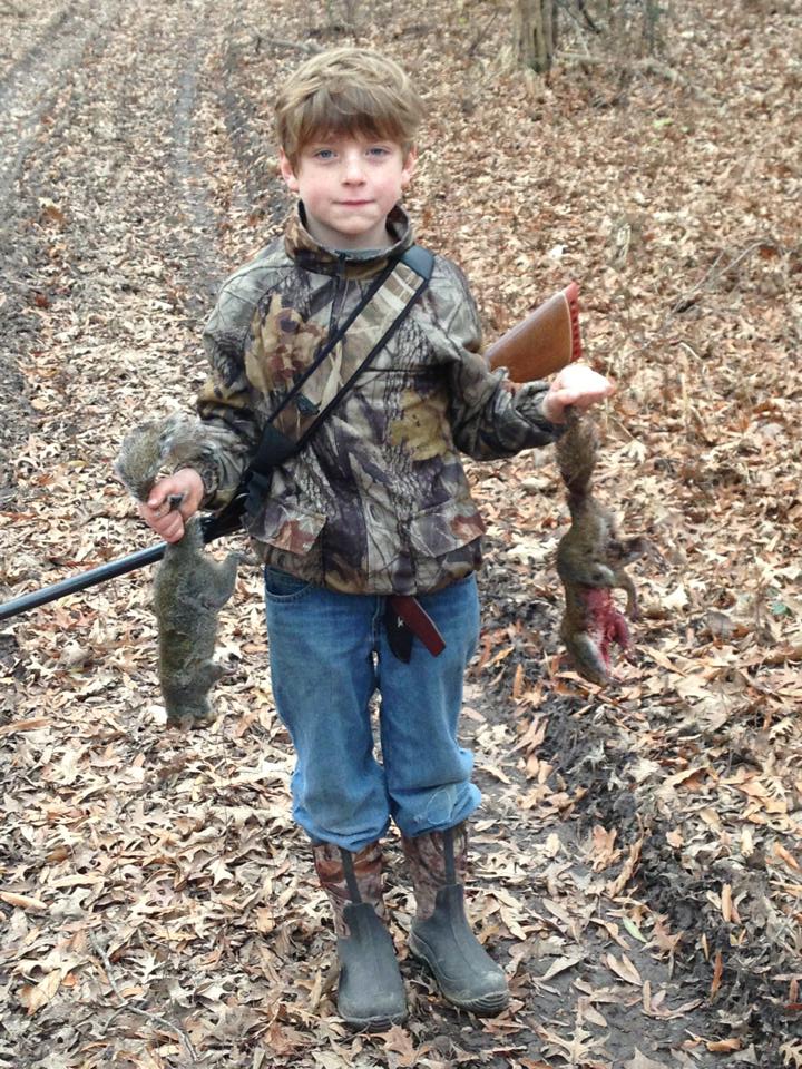A young boy with his harvest from squirrel hunting