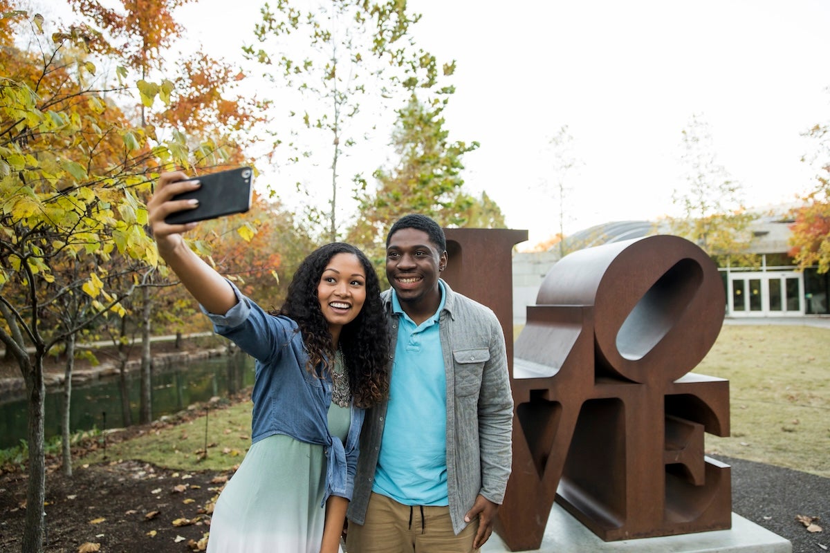 couple taking a selfie near the LOVE sculpture at Crystal Bridges