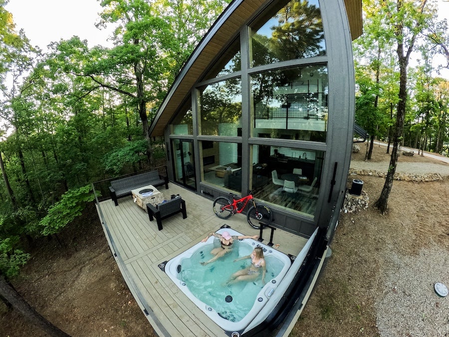 ladies soaking in a hot tub outside of the lodge at In The Trees