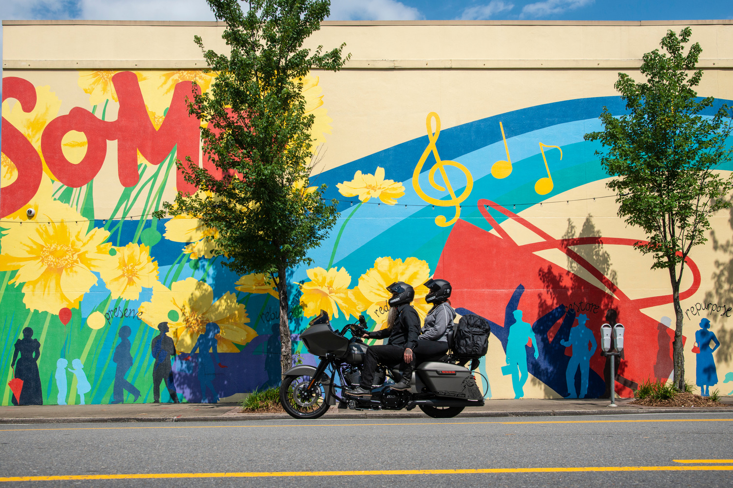 Motorcyclists stopped in front of a mural in SOMA.
