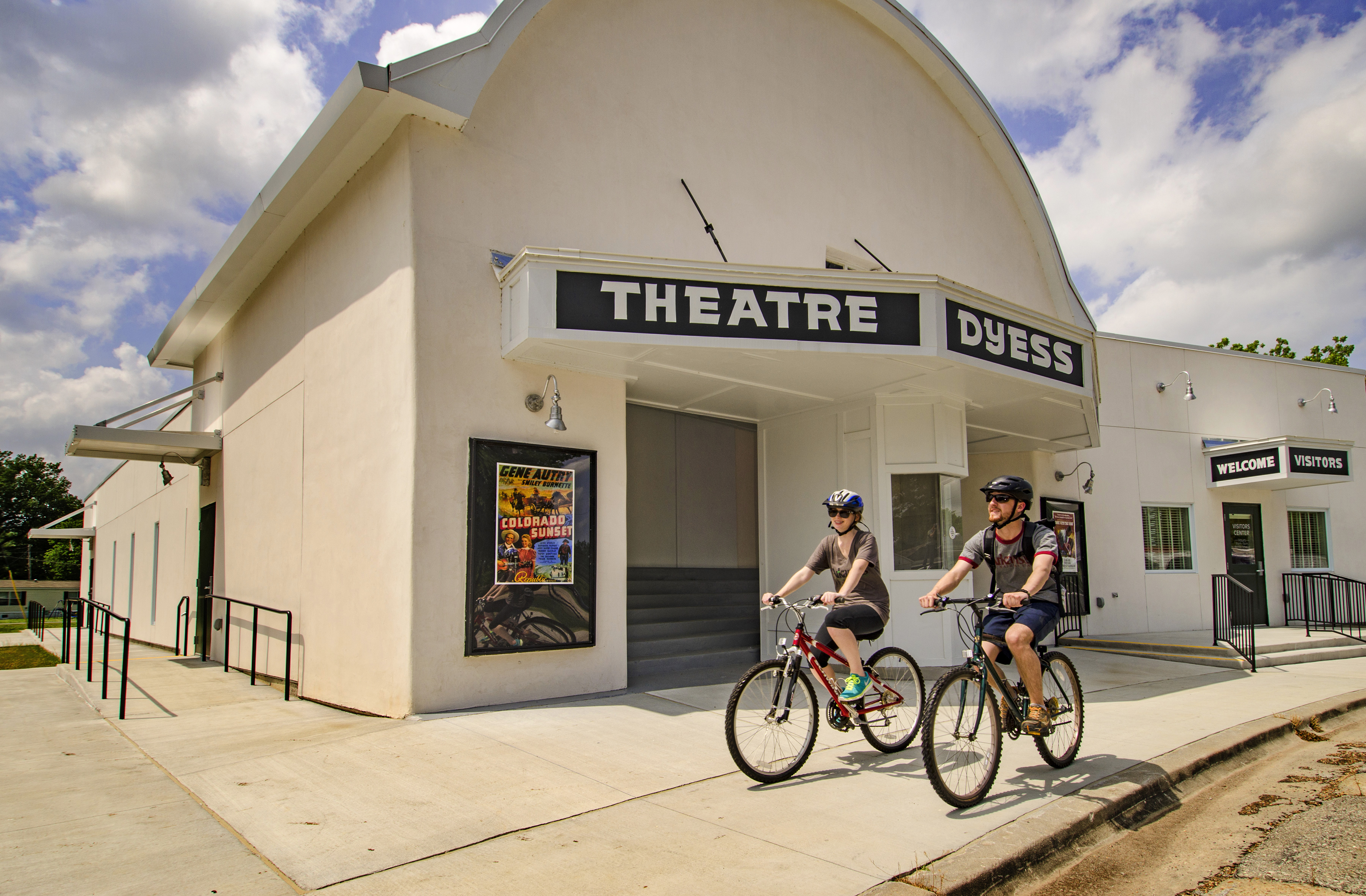 A couple biking past Theatre Dyess.