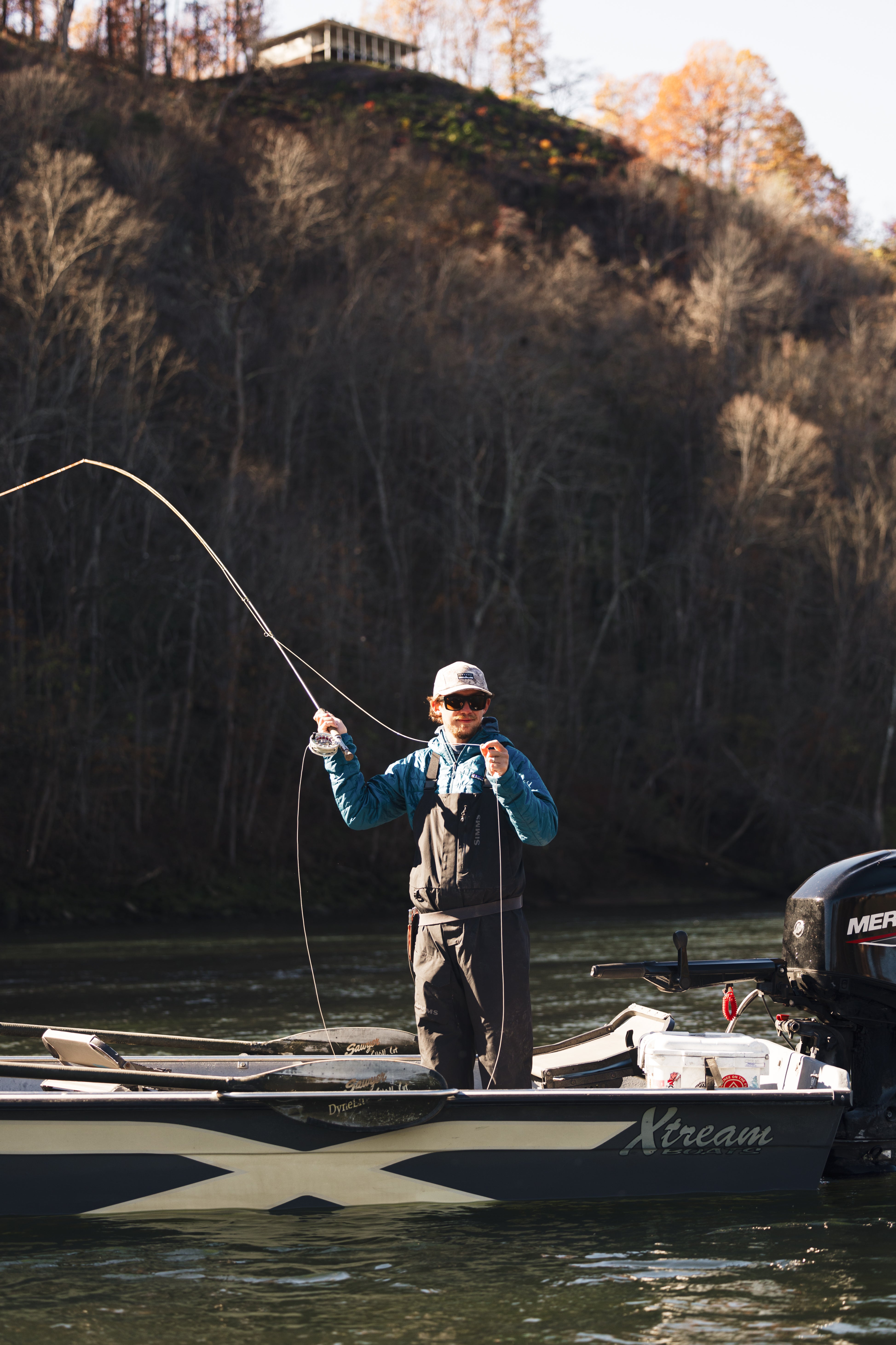 man fishing off a boat on the river