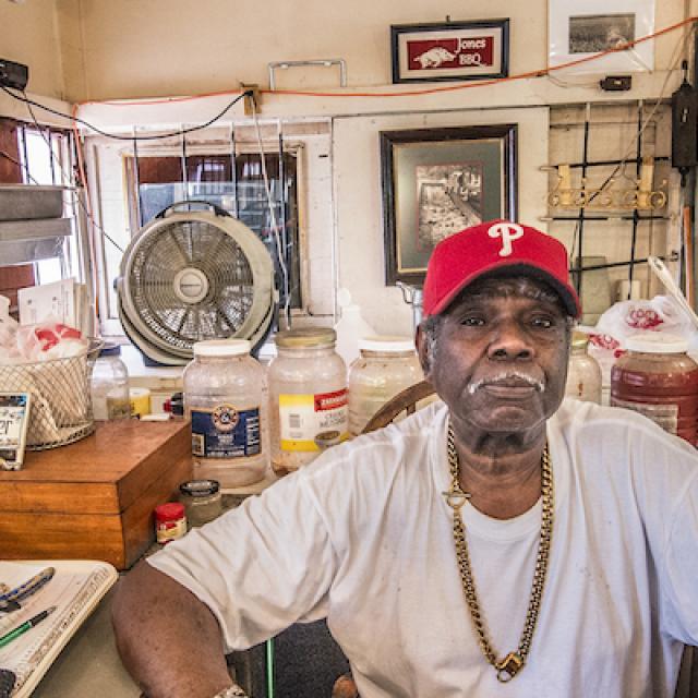 James Harold Jones sits in his kitchen after taking a break from smoking Bar-B-Q
