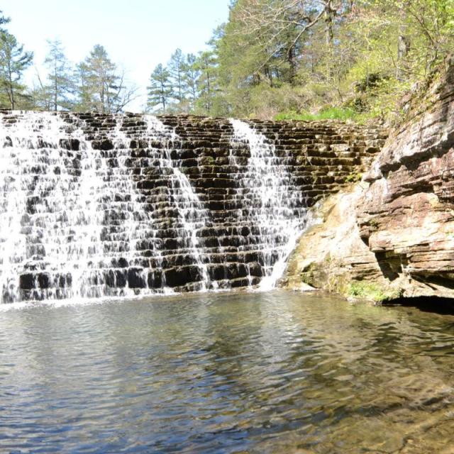 Waterfalls with trees and rocks around at Gunner Pool Recreation Area