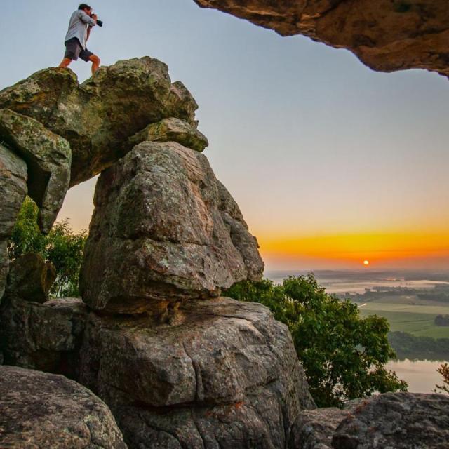 Hiker taking photo at sunset