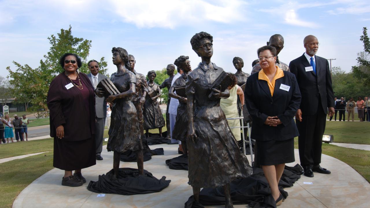 The original Little Rock Nine pose with the statue at the Capitol Dedication