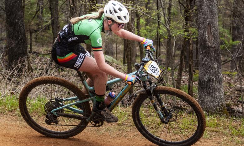 A woman rides a mountain bike on a trail.