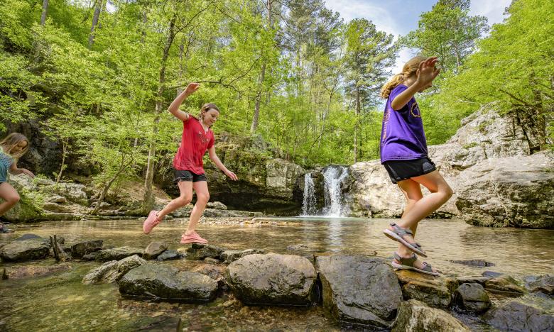 Kids splashing in the water at Lake Catherine near waterfall