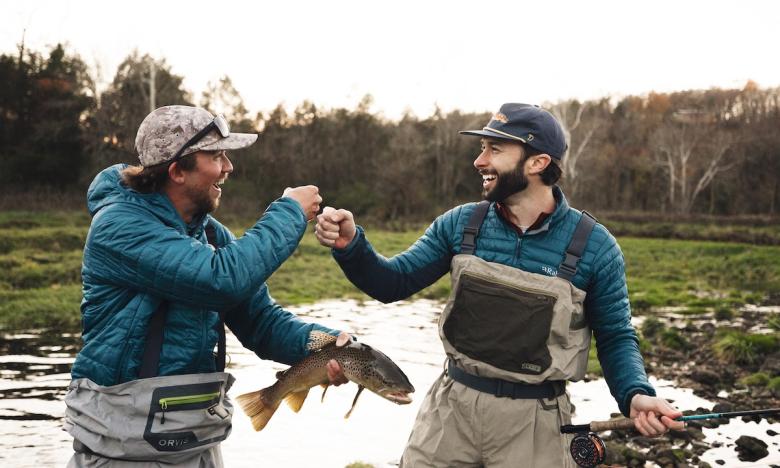 men fist bumping after catching a fish