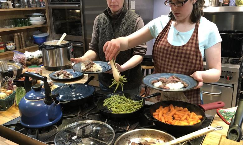 Ruth and her daughter serving dinner