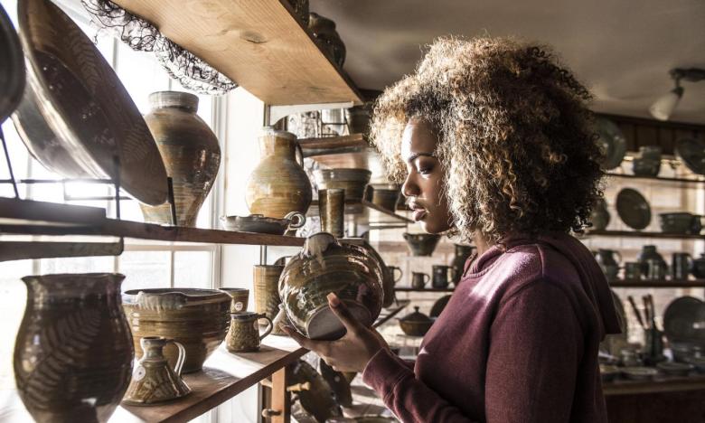 A woman looks at pottery made at Ozark Folk Center