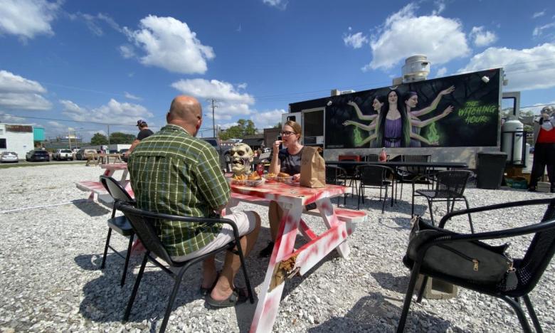 Diners at a picnic table at The Witching Hour food truck in Bentonville