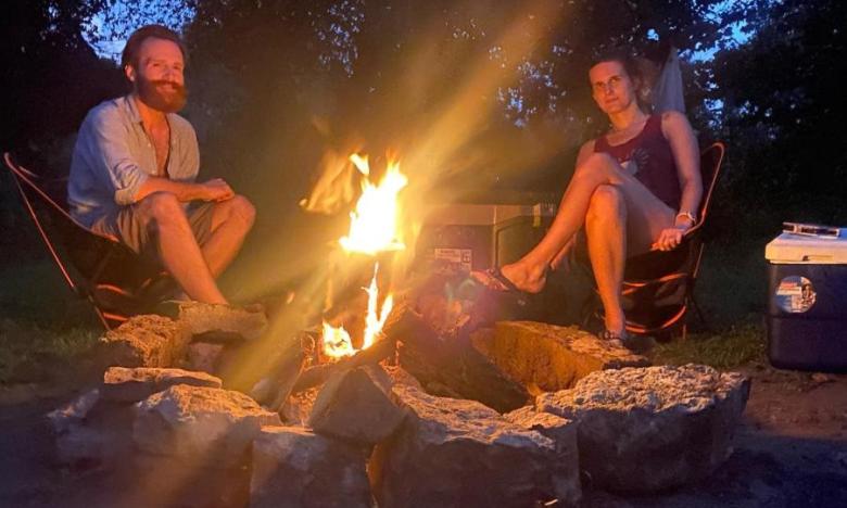 Campers sit around a fire at Gypsy Camp & Canoe