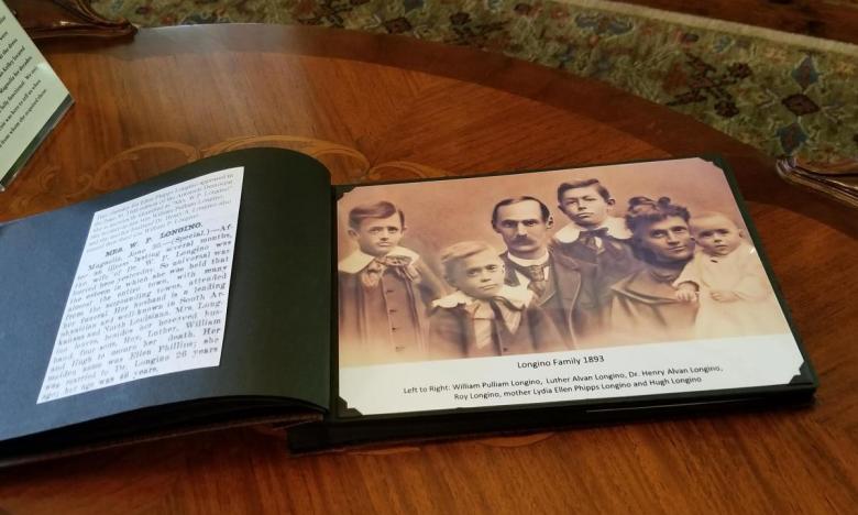 Family album displayed in South Arkansas Heritage Museum with information about the Longino family.