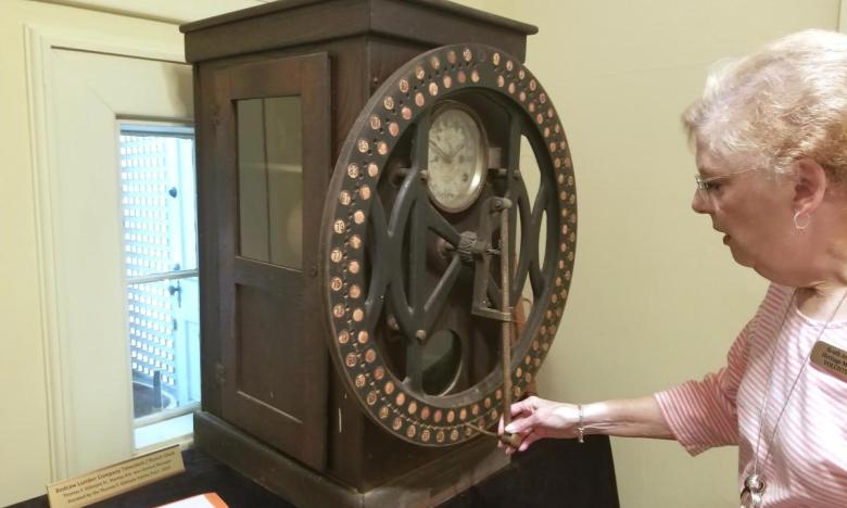 South Arkansas Heritage Museum Education Director Ann Mount demonstrates the time clock once used by employees of the Bodcaw Lumber Company.