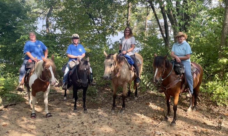 Riders pose for a picture with Lake Sequoyah in the background.