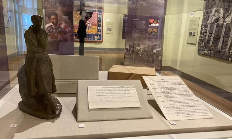 Historic artifacts on display at Women's Voices exhibit. This case has a sculpture of Eleanor Roosevelt which is on loan from Hillary Clinton and a draft of the Universal Declaration of Human Rights section with Roosevelt's handwritten notes.