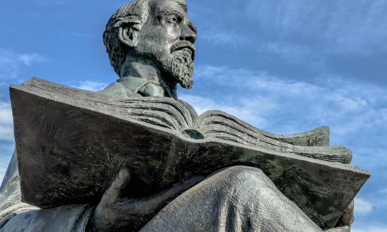 statue of a man reading a book