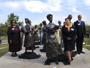 The original Little Rock Nine pose with the statue at the Capitol Dedication
