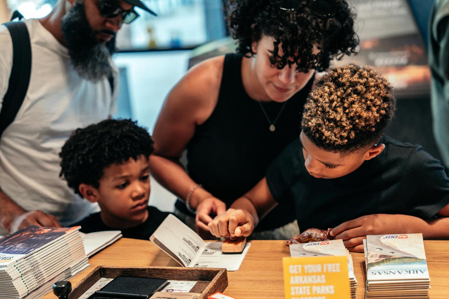 Family looking at brochures at a table; two children with an adult.