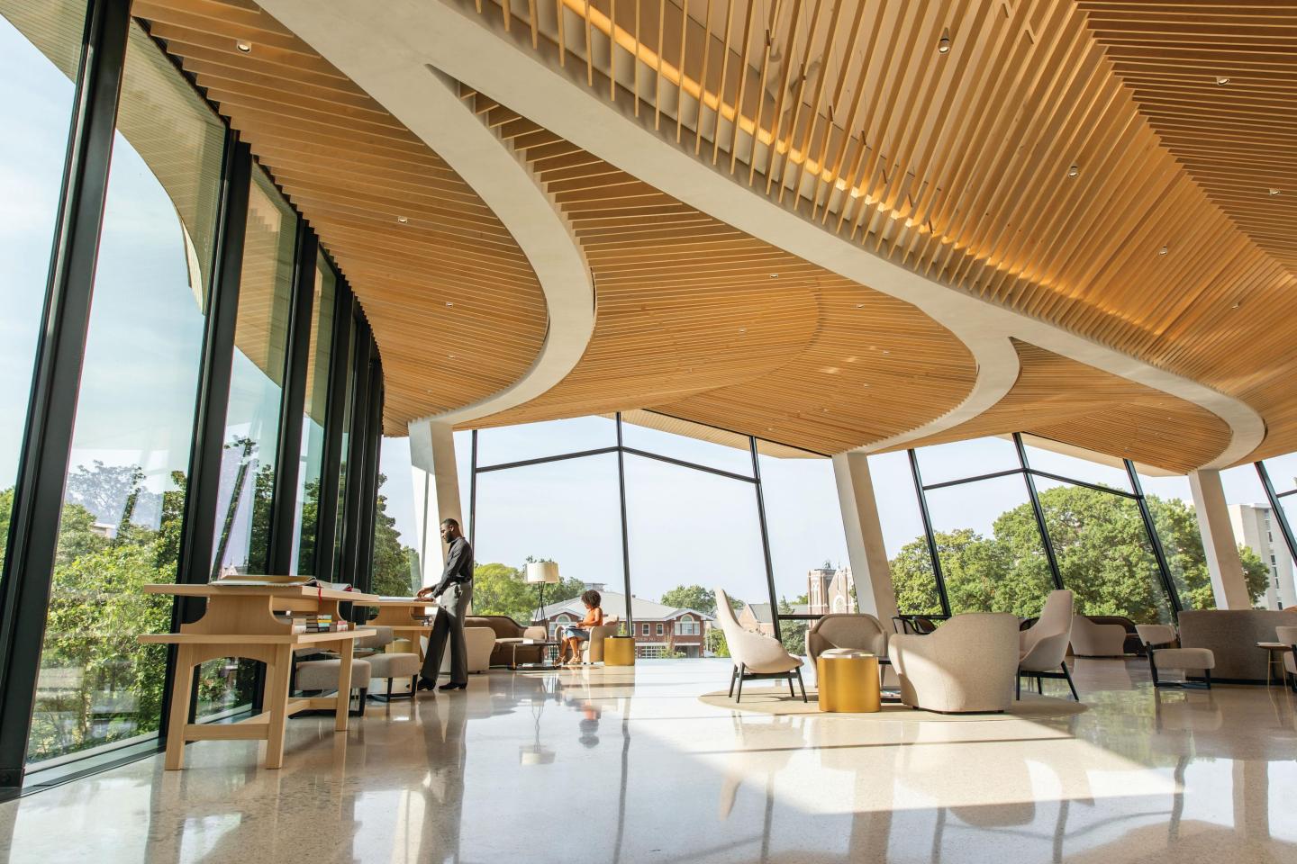Spacious modern lobby with curved wooden ceiling and large windows.