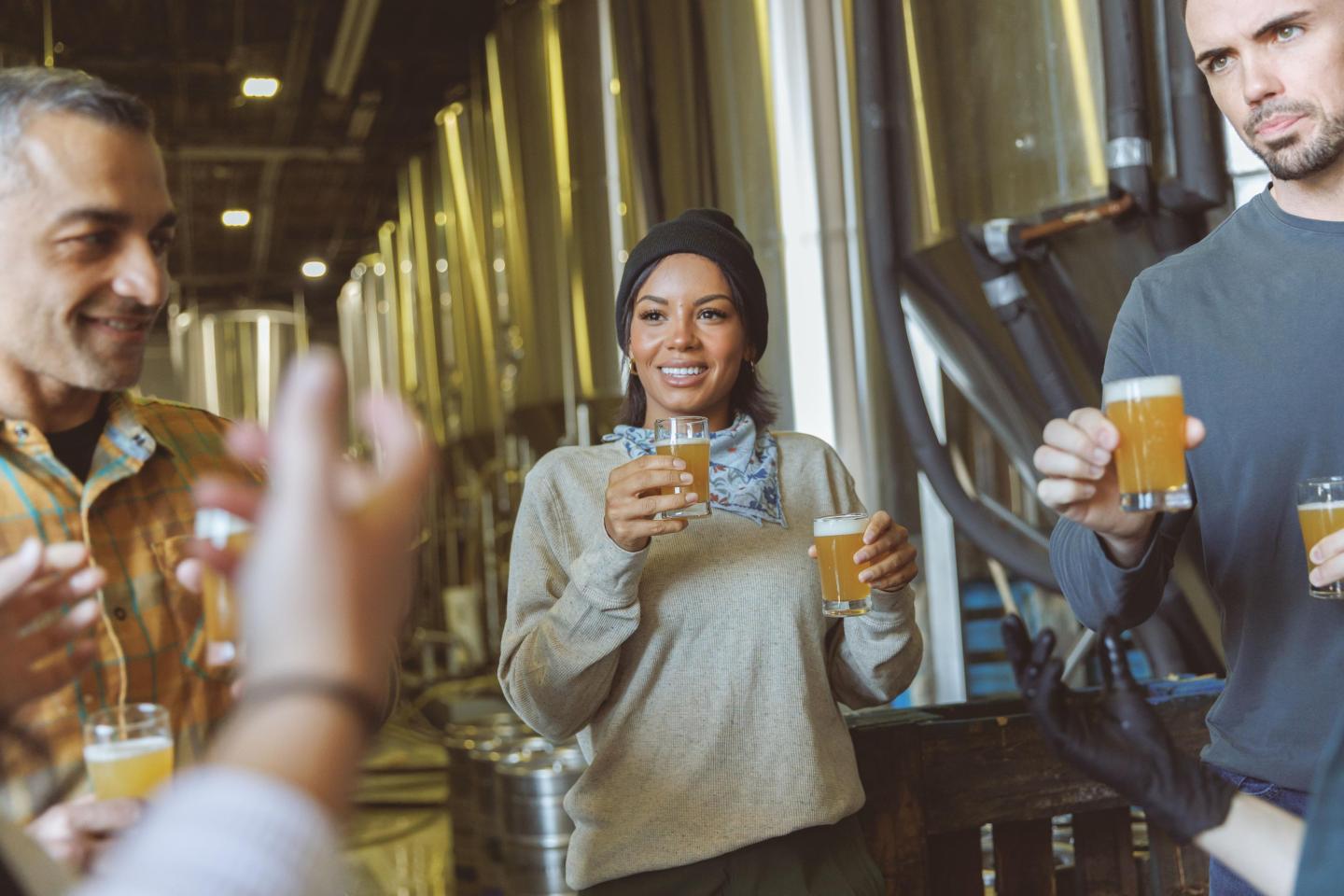 People enjoying drinks together in a brewery setting.