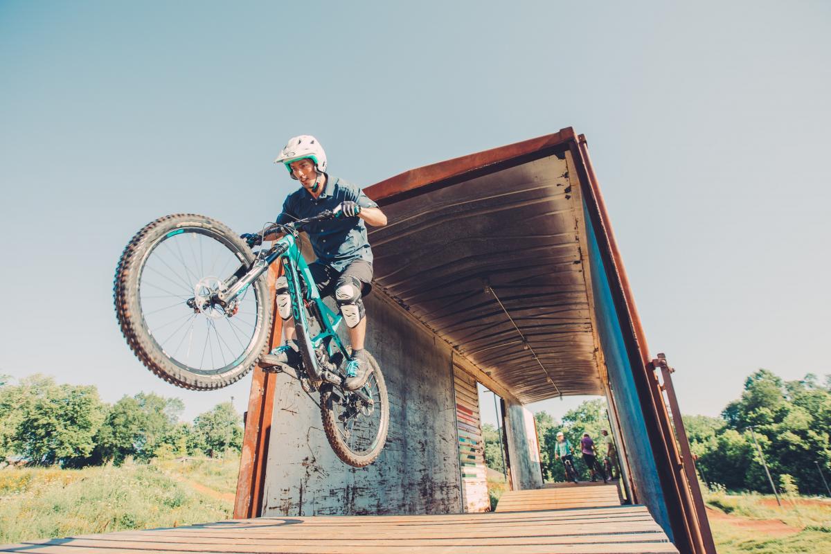 Biker jumping off a ramp with a blue sky background.