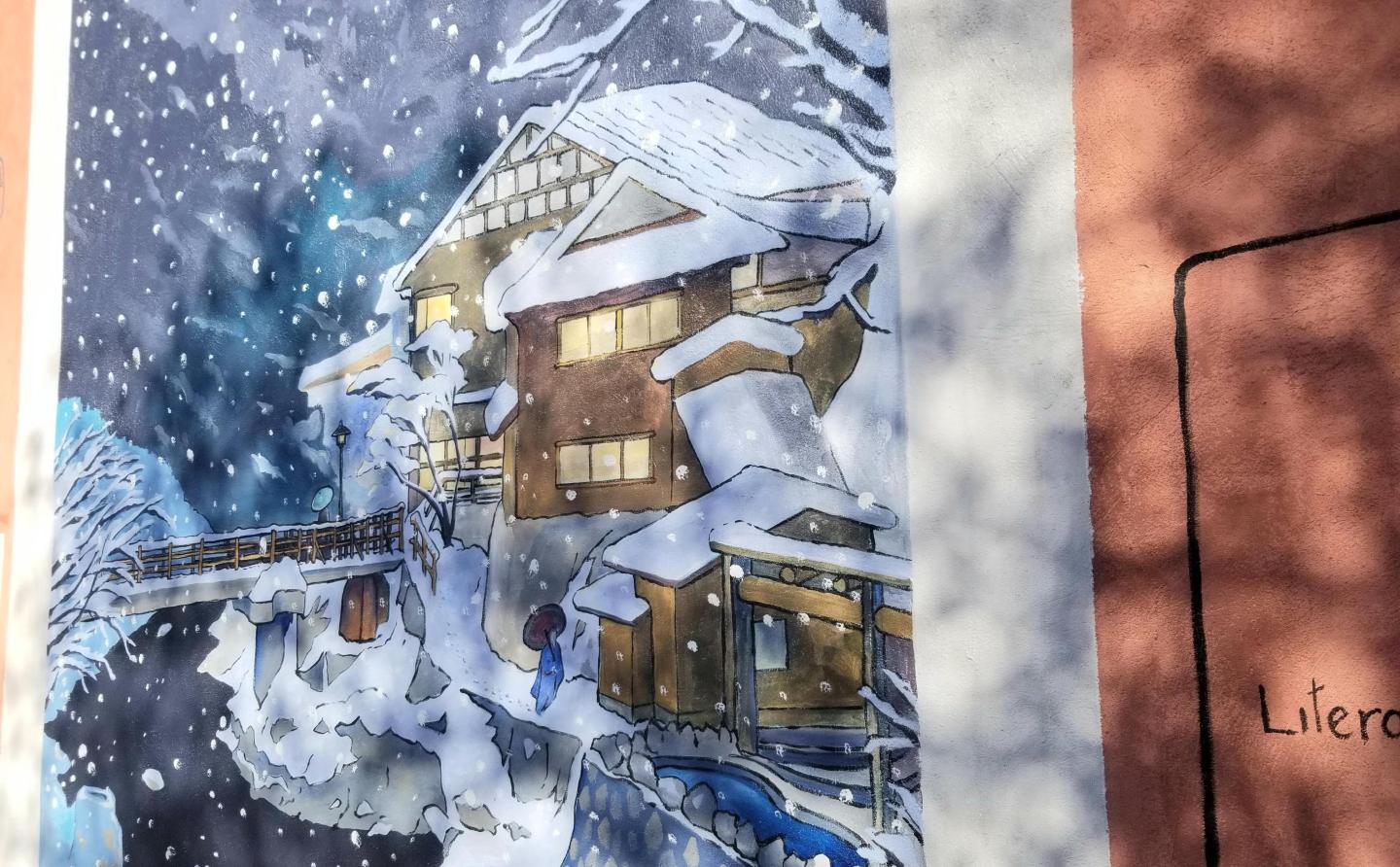 Snowy mountain lodge with warm lights, surrounded by trees.