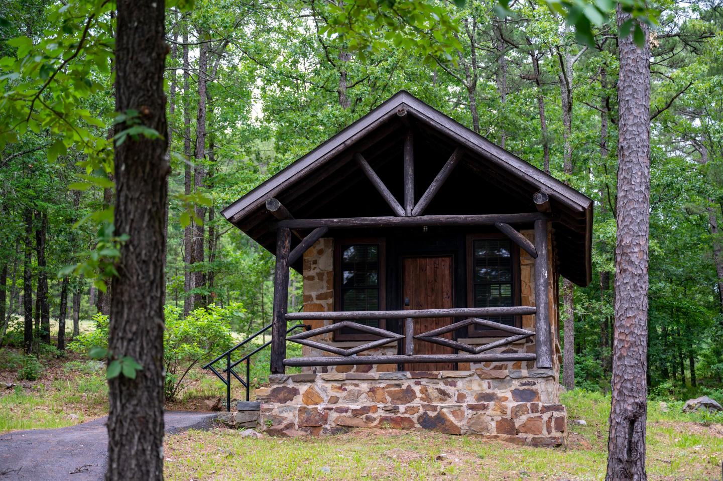 Cozy log cabin surrounded by lush green trees.