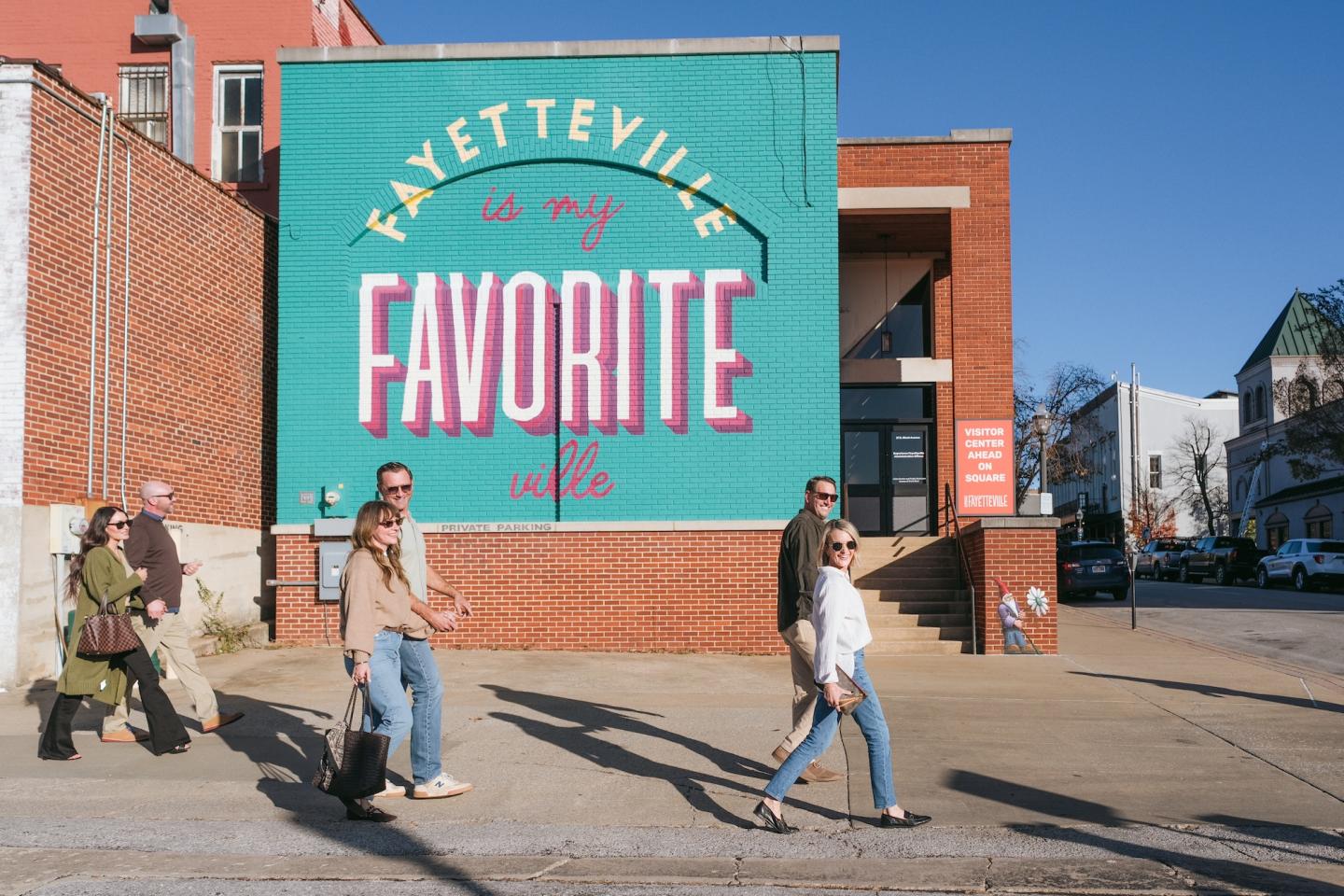 Colorful mural on building exterior with people walking by.