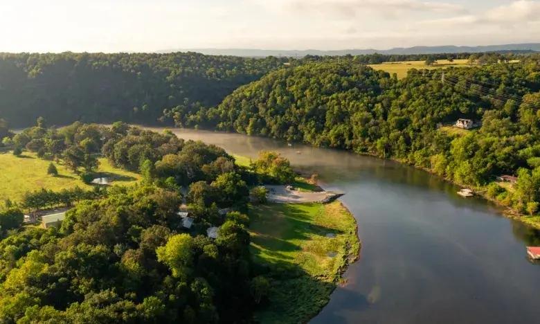 Aerial view of a river winding through lush green hills.