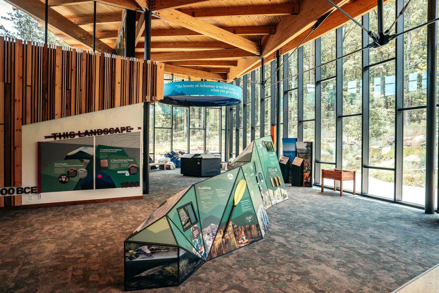 Spacious visitor center with exhibits, large windows, and wooden ceiling beams.