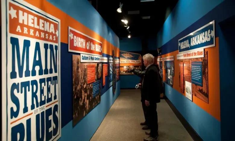 Exhibit hallway with vibrant blues and oranges, person observing displays.