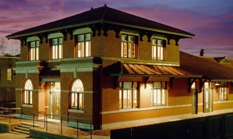 Historic brick building with lit windows at dusk.