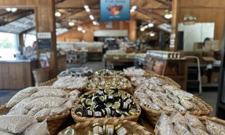 Baskets of beans and candies in a rustic indoor market.