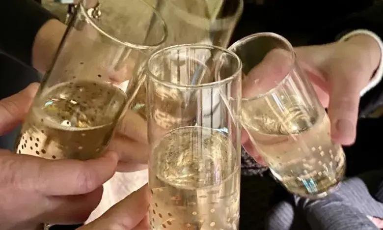 Clinking champagne glasses in a celebratory toast.