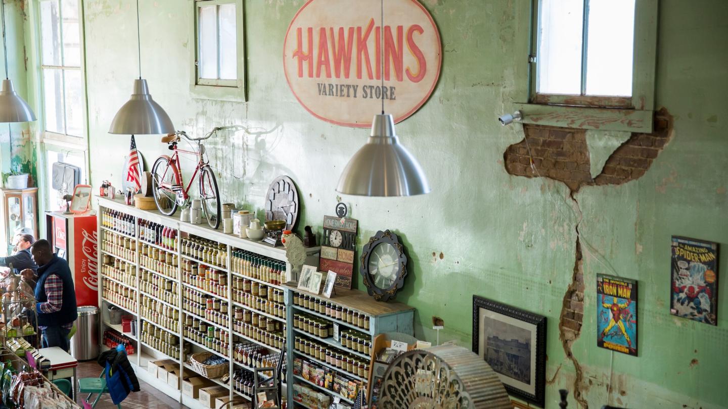 Vintage store interior with rustic shelves and a worn green wall.