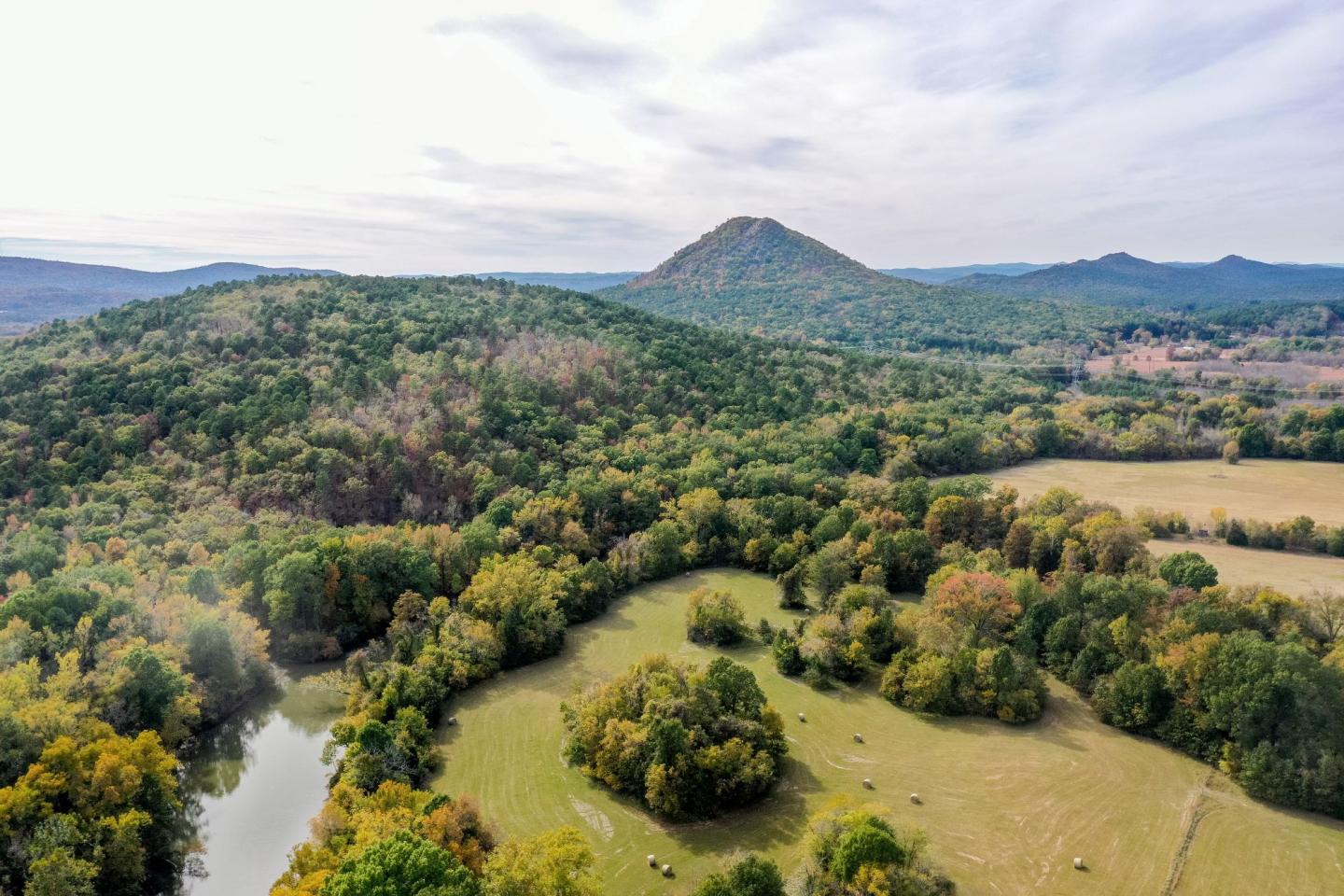 Aerial view of lush green hills and a distant mountain.
