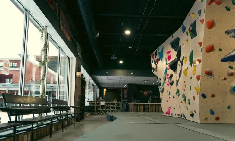 Indoor climbing gym with colorful holds and large windows.