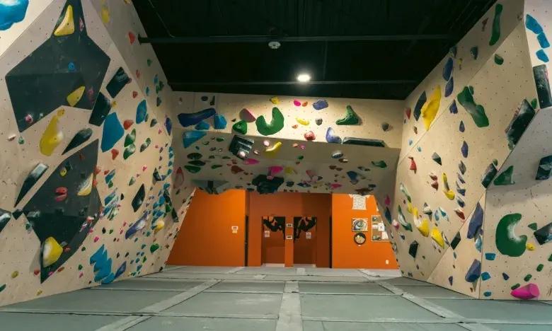 Indoor climbing gym with colorful holds on tall walls.