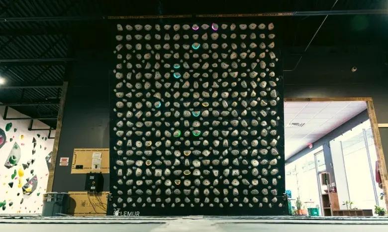 Indoor climbing wall with colorful holds in a gym setting.