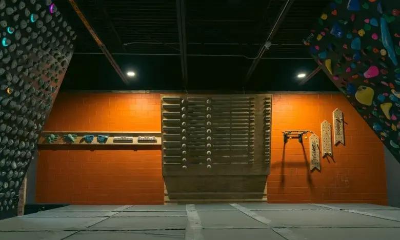 Indoor climbing gym with colorful climbing holds on walls.