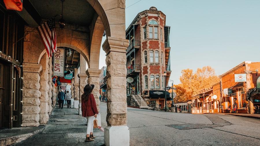 Historic town street with ornate buildings and autumn trees at sunset.