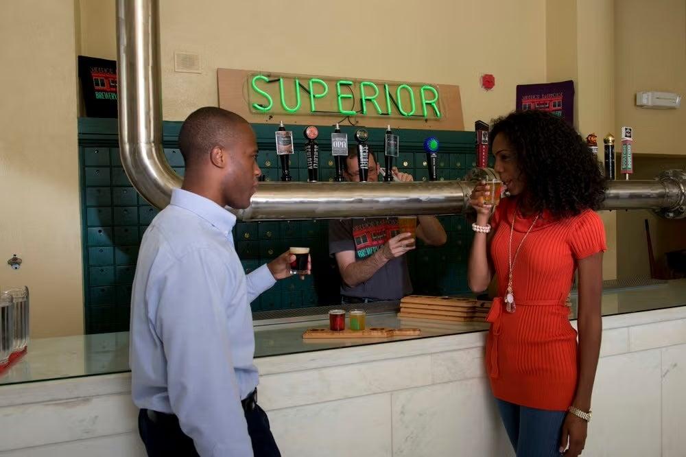 Man and woman enjoying drinks at a bar counter.
