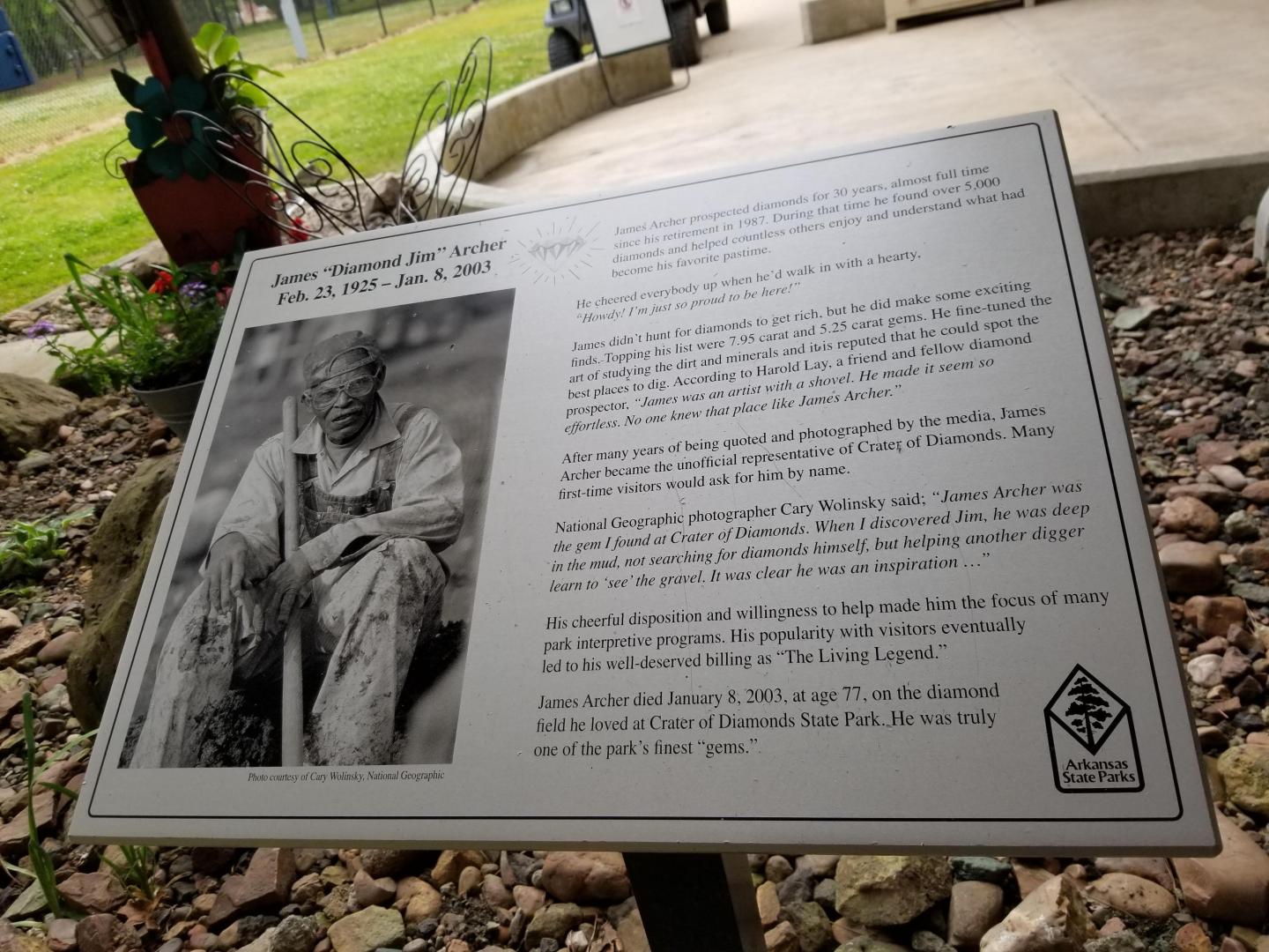 Informational plaque with text and a historic photo outdoors.