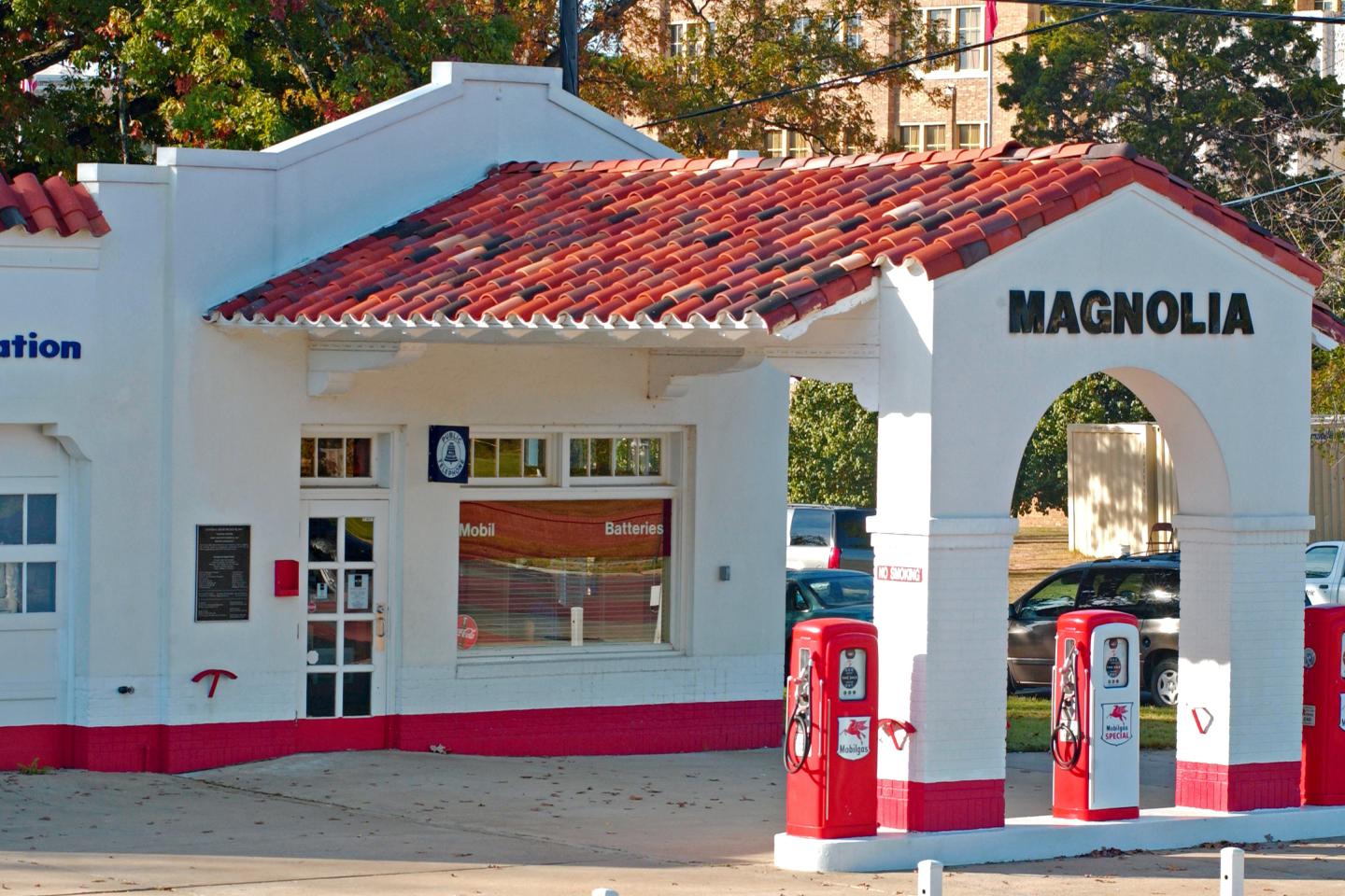 Historic gas station with red pumps and a tiled roof.