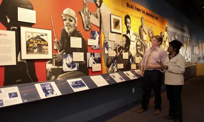 Exhibit featuring jazz musicians with two people observing.